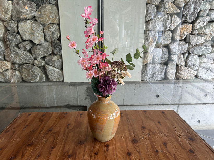 桜などの造花を花瓶にさして玄関横の木の台に飾っている