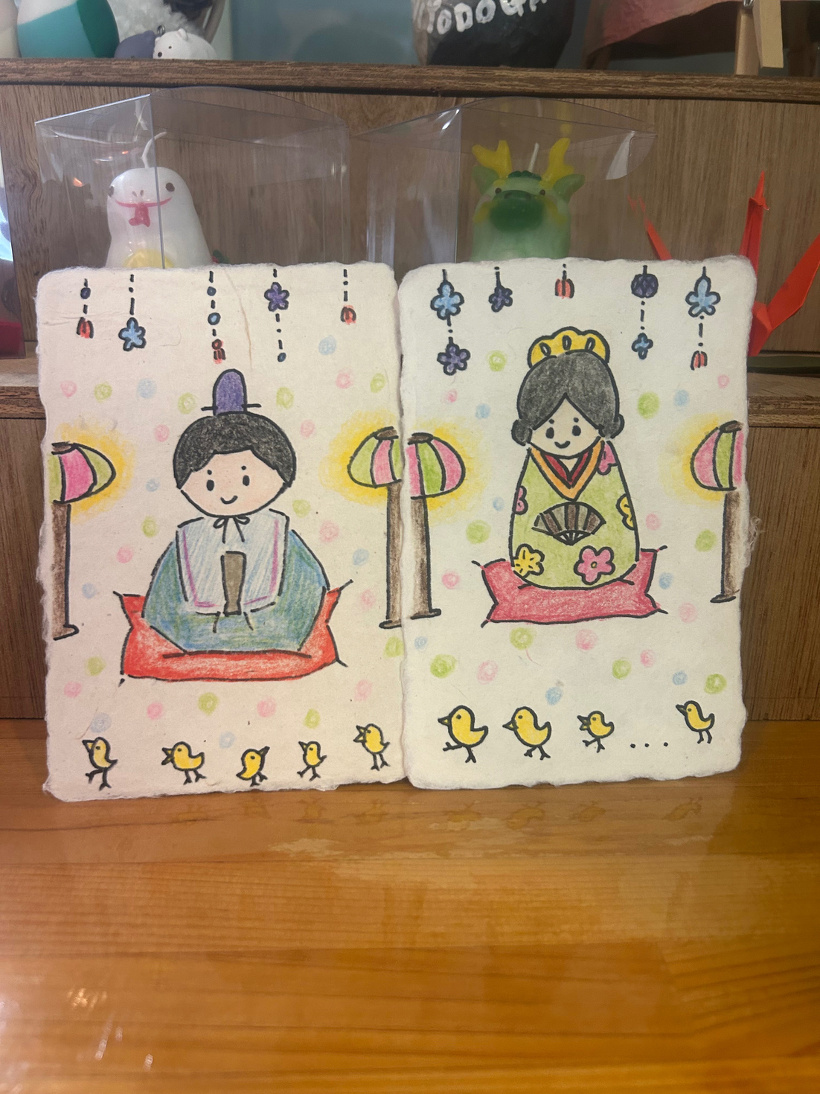 和紙のはがきに色鉛筆でお内裏様とお雛様を描いている。各1枚