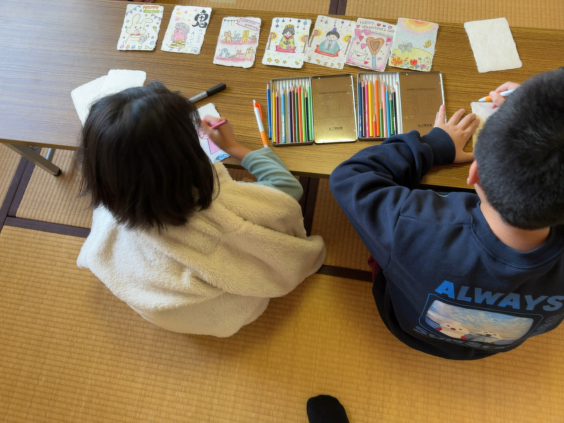 2人並んで絵葉書を描いている