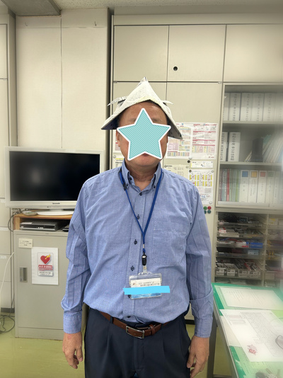 事務長が新聞紙兜をかぶっています
