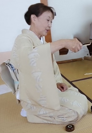先生が茶杓を持ち教えている