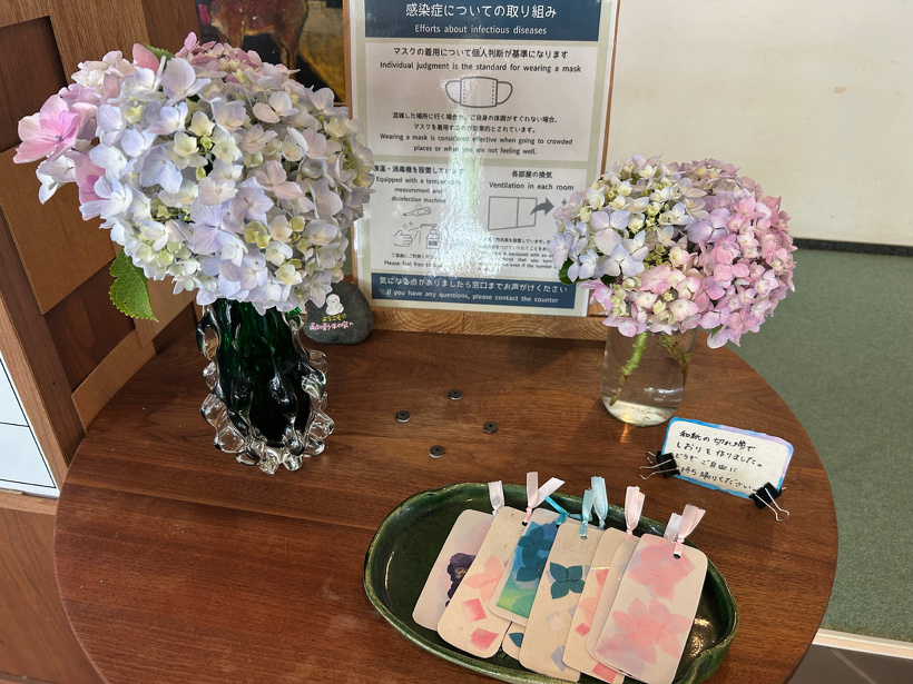 館内1階ロビーにあるテーブル。花瓶に生けたアジサイとしおりがある。