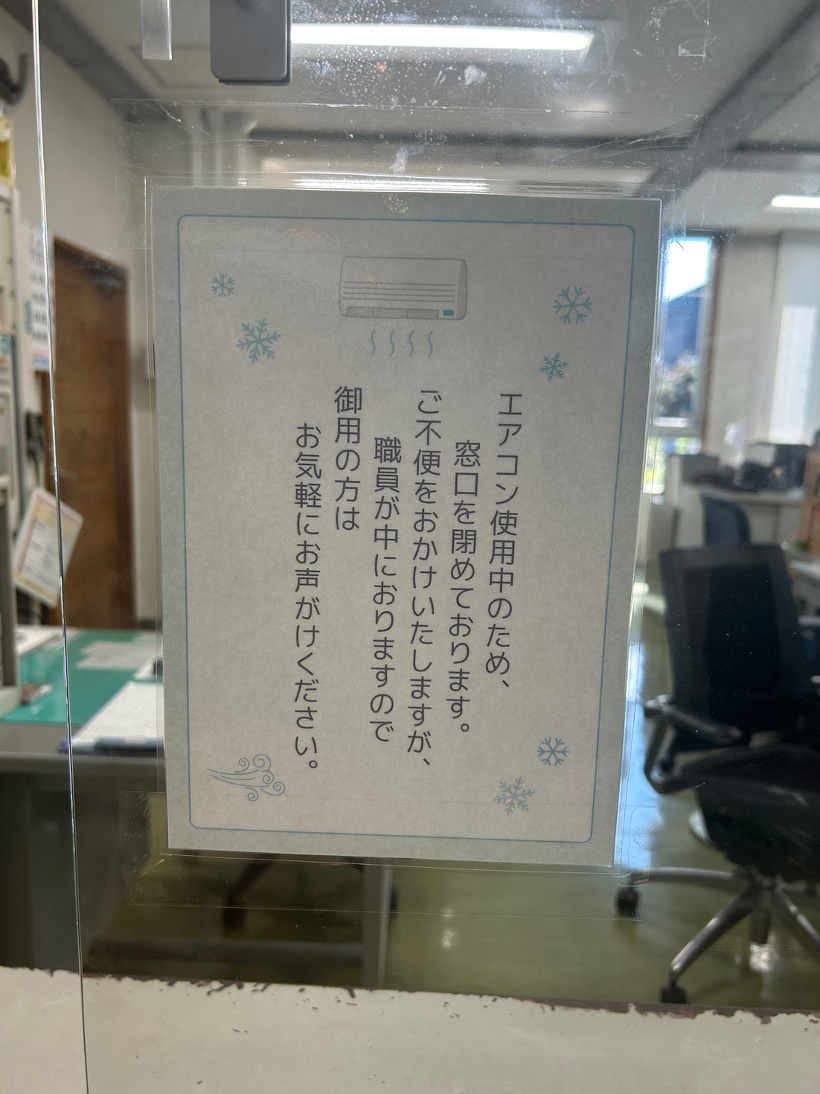 事務所窓口にある「エアコン使用中のため窓口を閉めている」旨の貼り紙