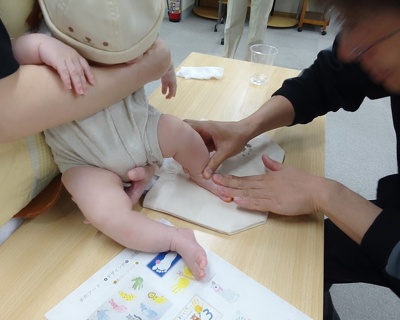 お子さんの足形をバッグにスタンプしている様子
